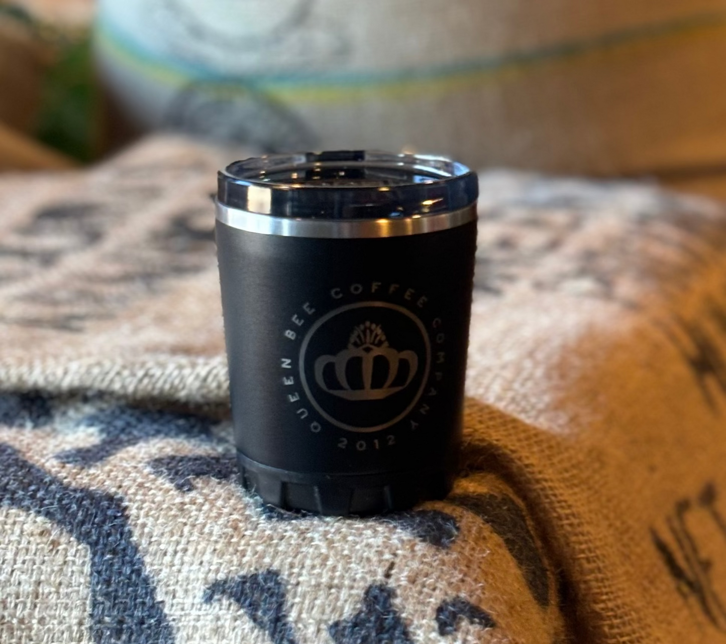 Black coffee canister with a logo on a burlap bag