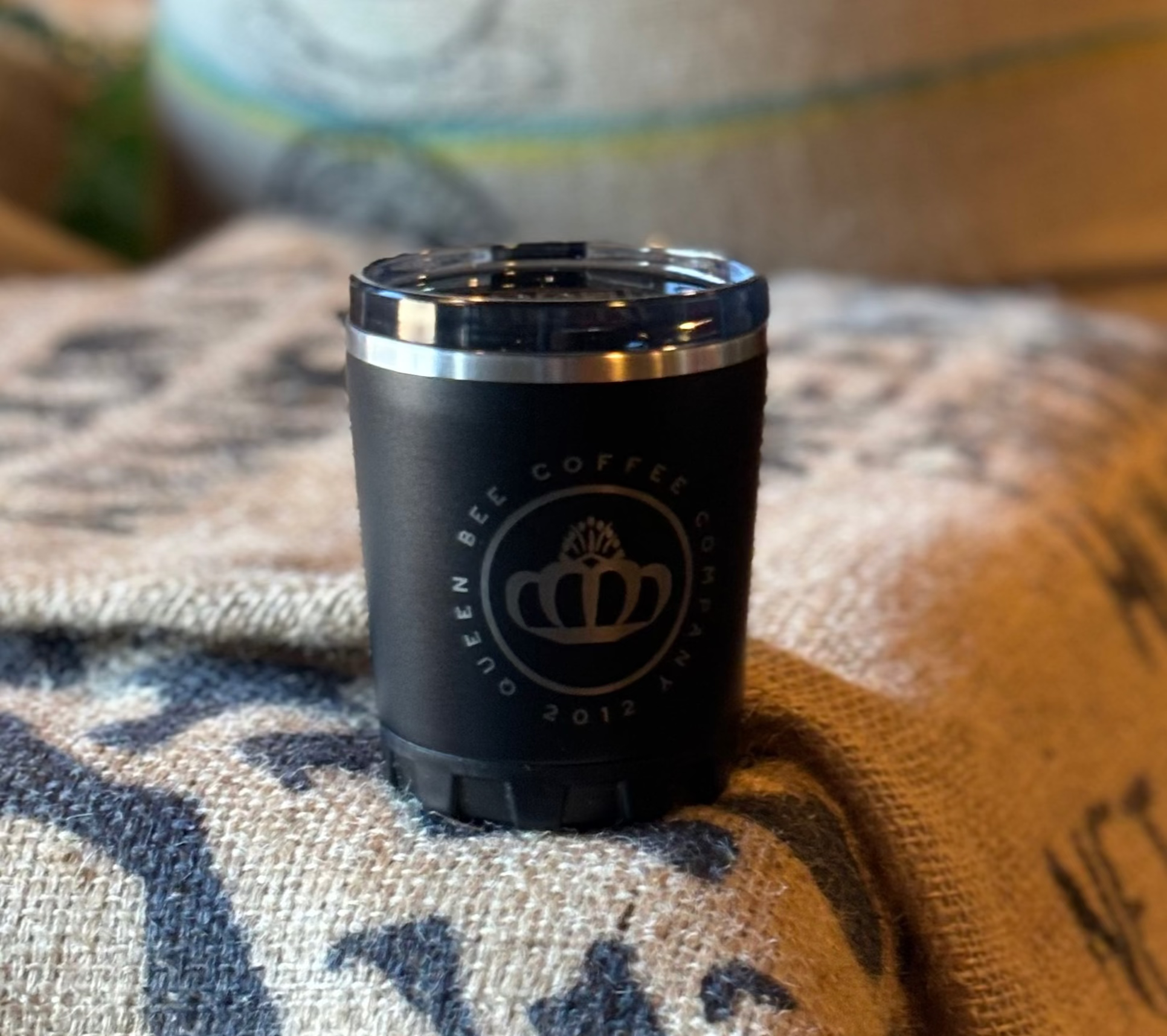 Black coffee canister with a logo on a burlap bag