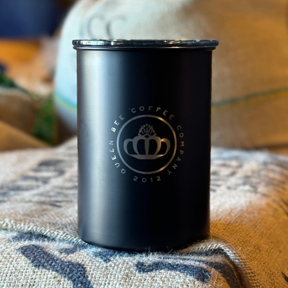 Black insulated tumbler with a logo on a textured surface