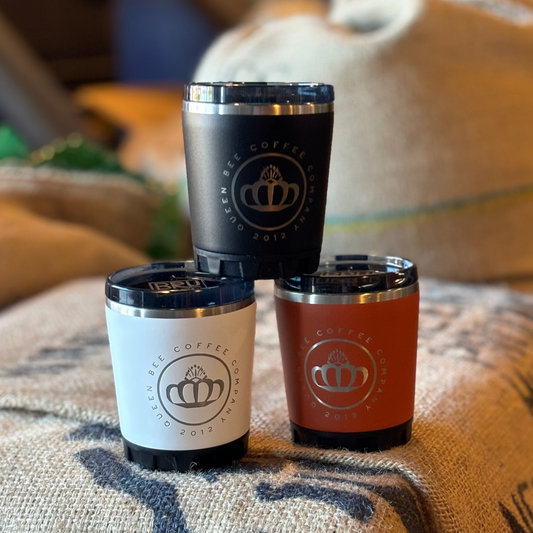 Three insulated coffee cups with a brand logo on a textured surface.